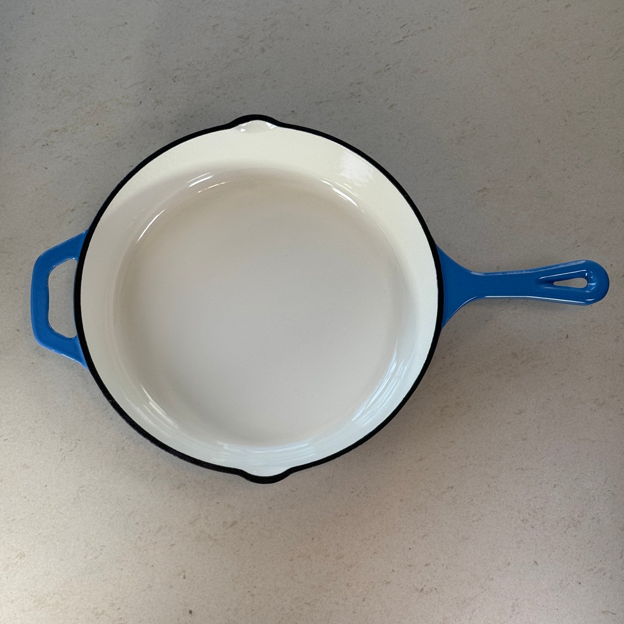 Intérieur anti adhésif clair d’une poêle en fonte émaillée Bleu Perle pour cuisson homogène et saisie parfaite