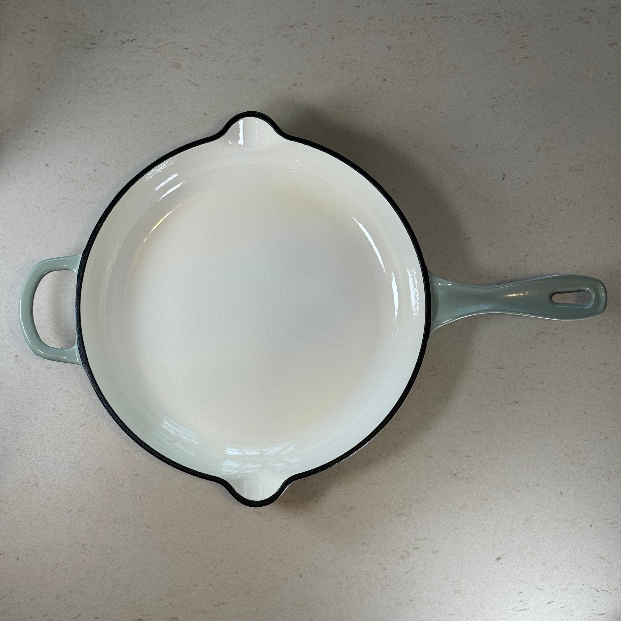 Intérieur anti adhésif clair d’une poêle en fonte émaillée Vert Sauge pour cuisson homogène et saisie parfaite